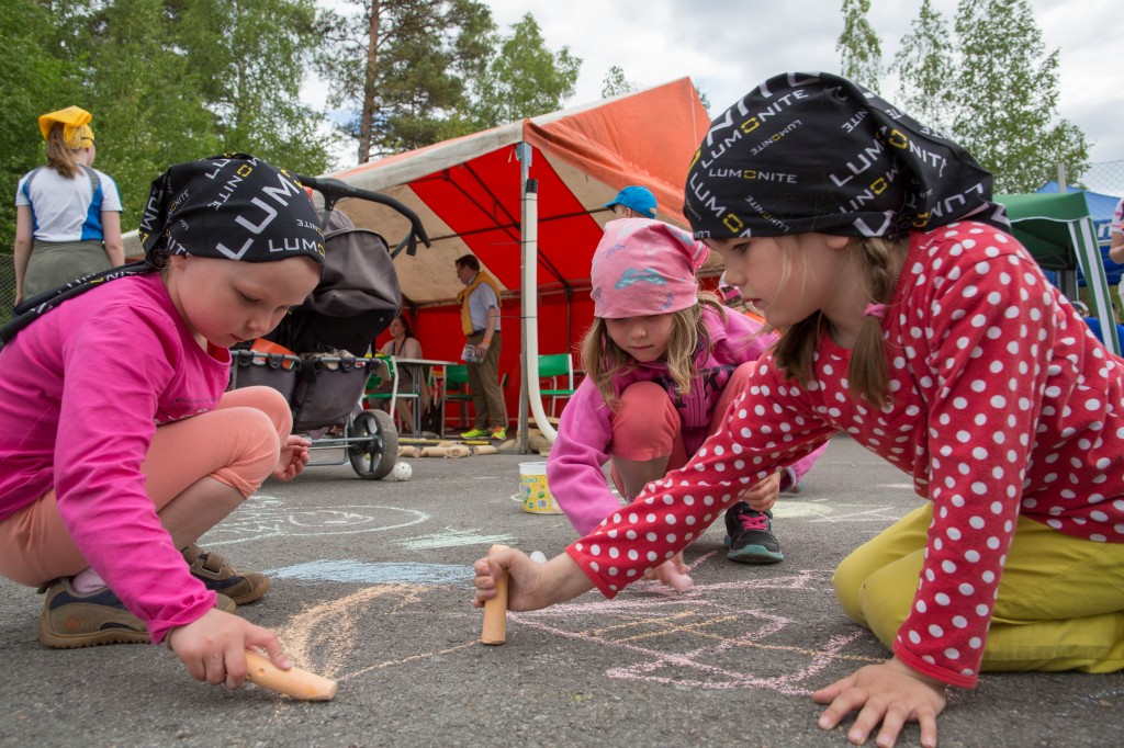 Outi, Anni ja Linnea koristelivat lastenmaailman asvalttia. Kuva: Ilkka Metsälä
