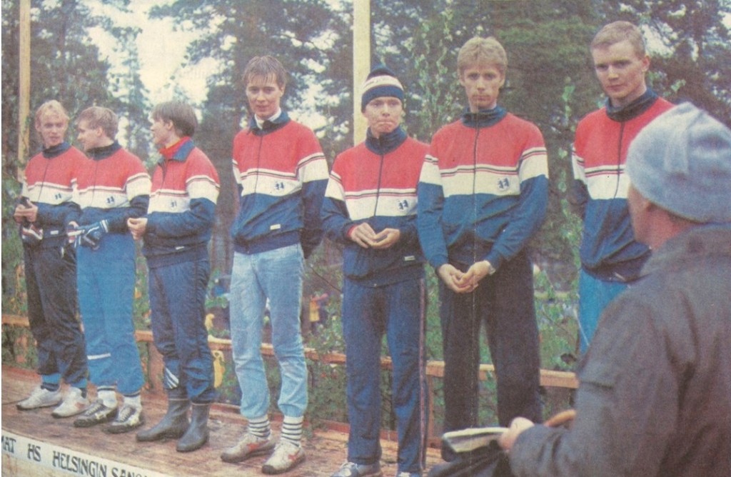 Karhukoplan pojat Laitilan Jukolan palkintokorokkeella juoksujärjestyksessä oikealta Timo Pöysti, Veli-Pekka Nurmi, Risto Metsälä, Jyrki Ankelo, Olli Ranta, Leo Pyymäki ja Juha-Pekka Harju. Selin oikealla esittelijänä jo edesmennyt kuuluttajalegenda Asser Kimpi. Kuva: Satakunnan Kansa.