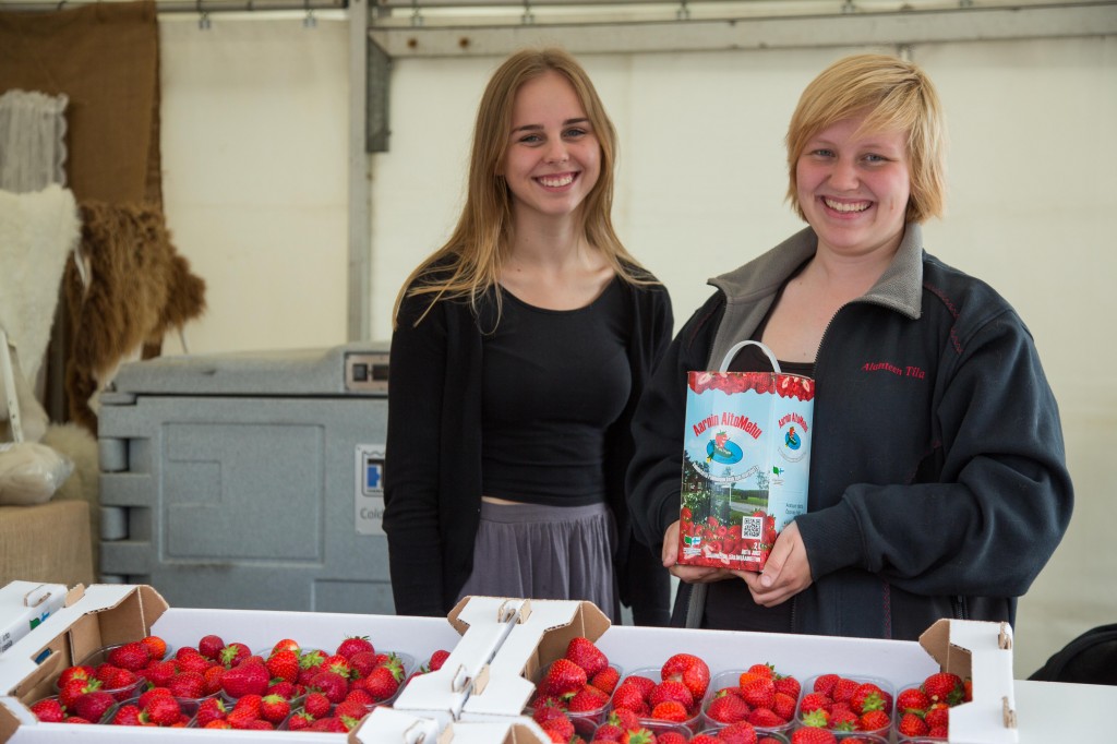 Emmi Niskala (vas.) ja Vilma Saarinen paimiolaiselta Alanteen tilalta kannustavat Jukola-väkeä maistamaan mansikoita.