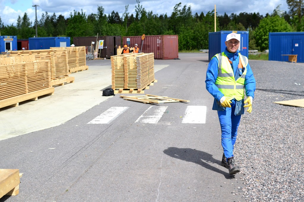 Harri Tuliniemi taustallaan Louna-Jukolasta purettuja aitaelementtejä.